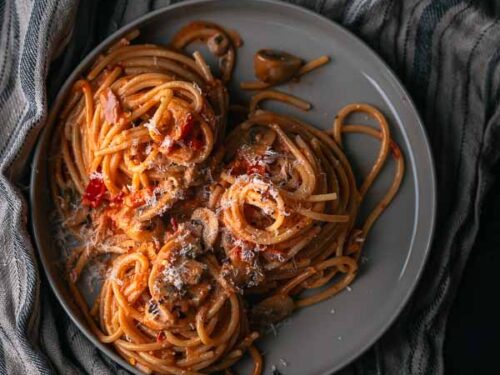 Spaghetti met tomatenroomsaus vol champignons, puntpaprika en ham