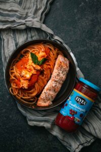 Spaghetti met romige zalmsaus en een stukje zalm naast