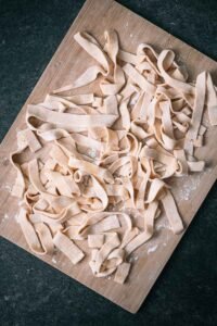 Zelfgemaakte tagliatelle op een houten plank