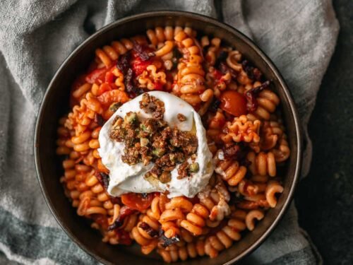 Pasta in tomatensaus met pancetta, burrata en pistachecrumble