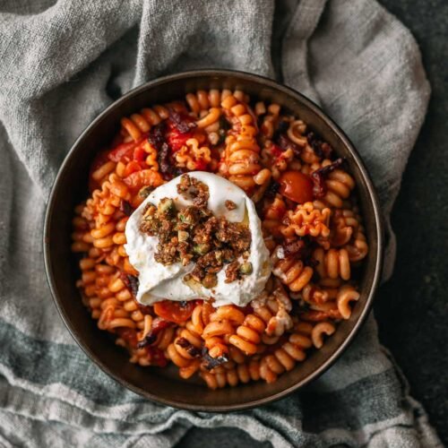 Pasta in tomatensaus met pancetta, burrata en pistachecrumble