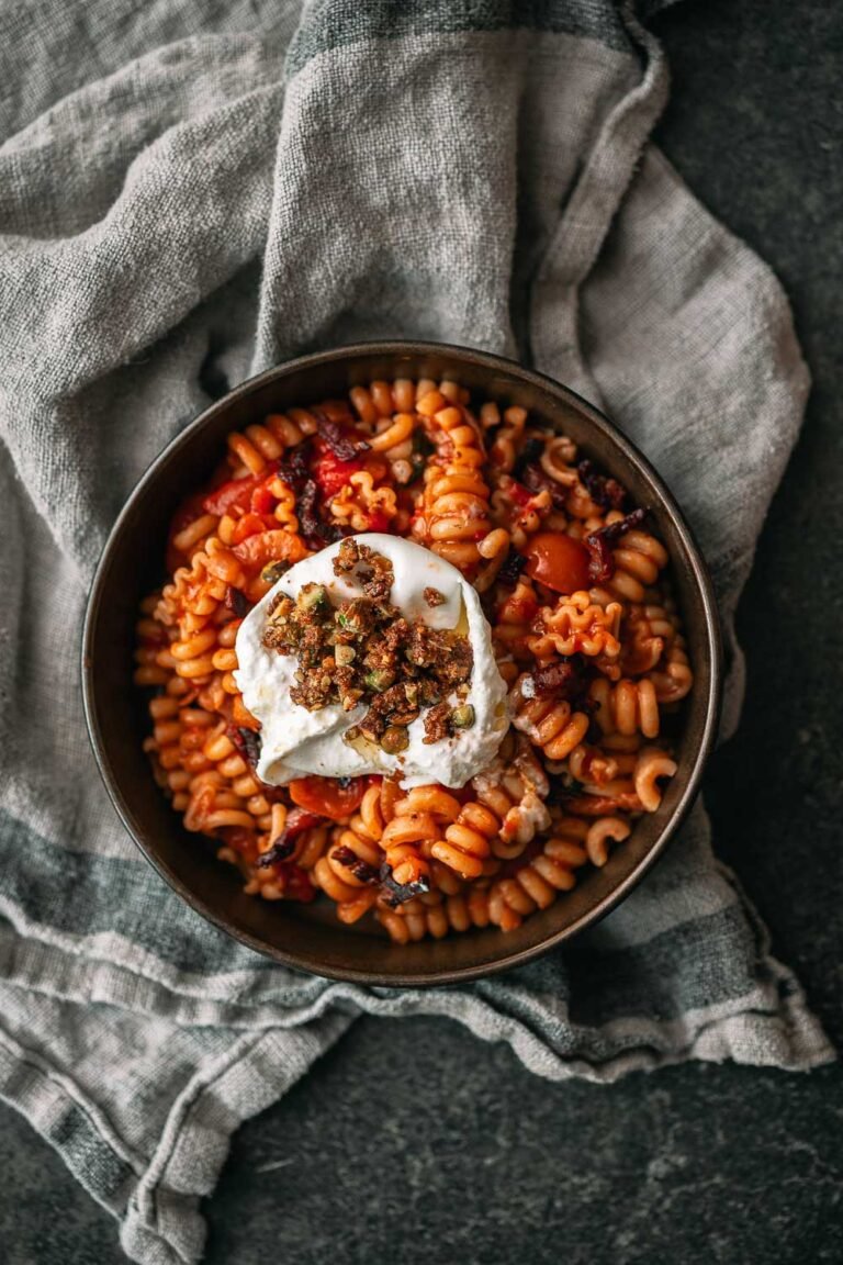 Pasta in tomatensaus met pancetta, burrata en pistachecrumble