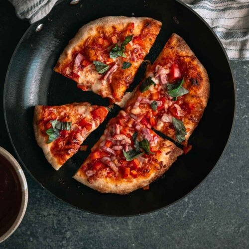 Krokante pan pizza met pancetta, paprika, mozzarella en basilicum