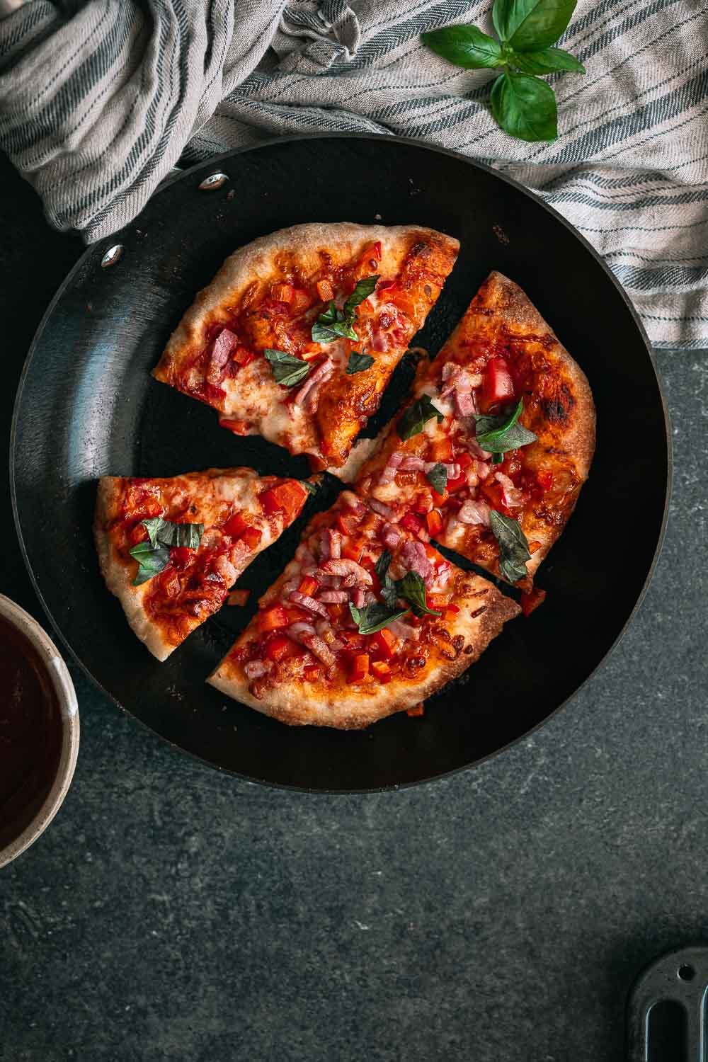Krokante pan pizza met pancetta, paprika, mozzarella en basilicum