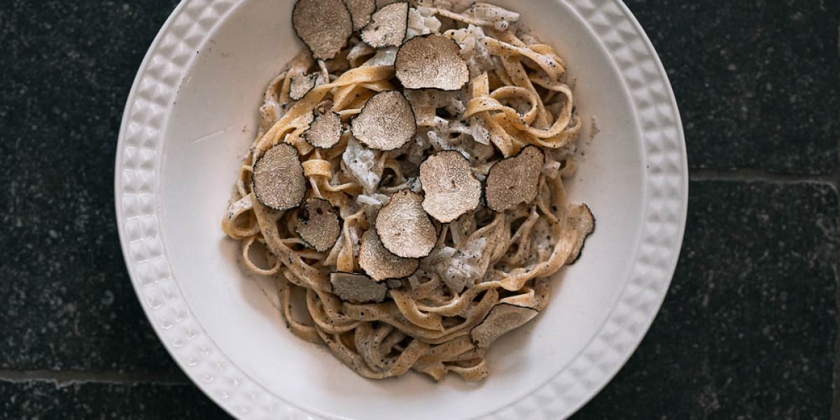Tagliatelle met truffelsaus en plakjes zwarte truffel