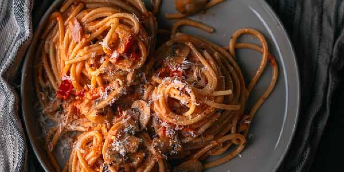 Spaghetti met tomatenroomsaus vol champignons, puntpaprika en ham
