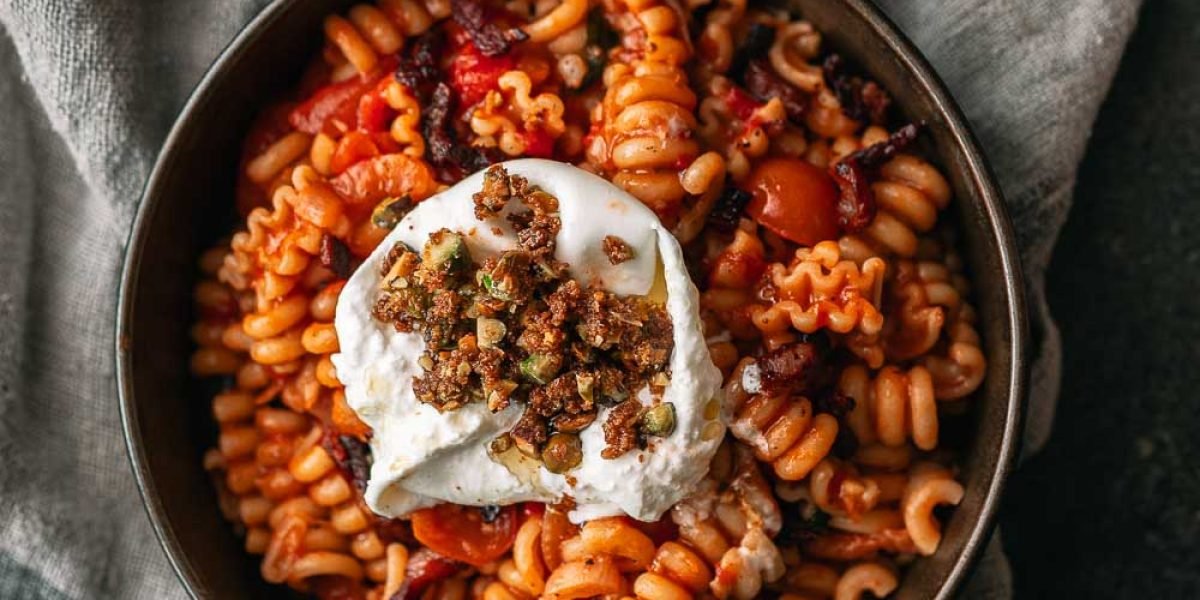 Pasta in tomatensaus met pancetta, burrata en pistachecrumble
