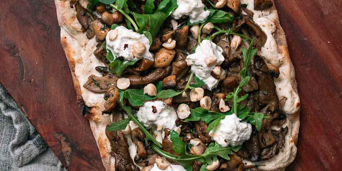 Herfstige Pinsa met champignons en truffel op ene houten plaat met een stoffen doekje eronder